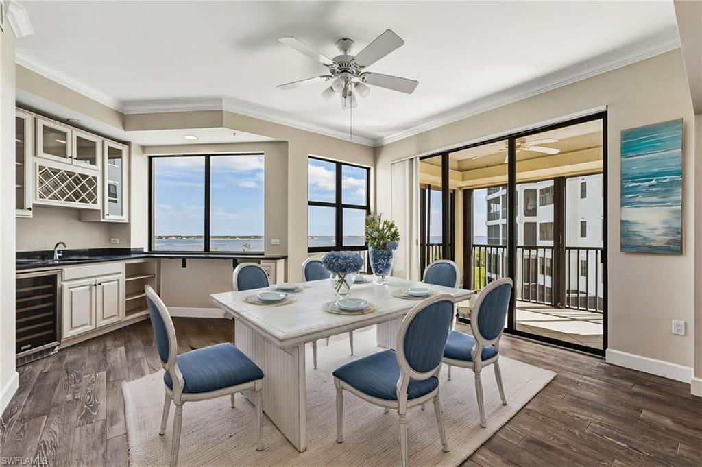 Image 2: From this vantage point, the views are truly breathtaking. A beautifully appointed wet bar features a wine cooler, wine rack, granite countertops, and ample overhead storage.Virtually Staged room.