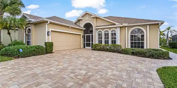 Image 3: Stucco exterior residence with a multi-tone paver driveway and pathway