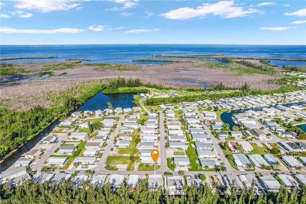 Image 2: Aerial overview of property's location with a nearby body of water and nearby suburban area
