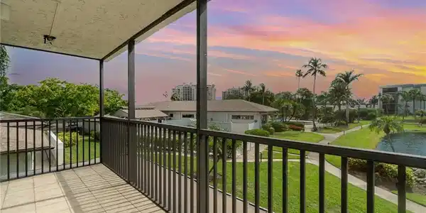 Image 2: Balcony at dusk, overlooks pond and lush, tropical grounds