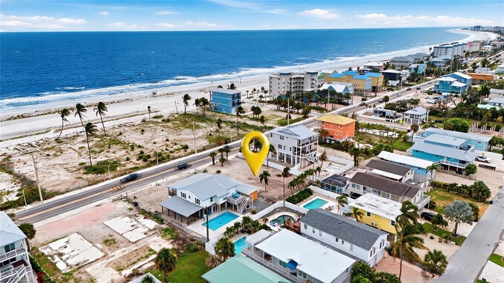 Image 4: VIRTUALLY ENHANCED - Coastal property featuring a primary residence with a private swimming pool, an elevated main living level, and covered parking beneath