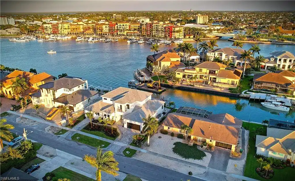 Image 1: Aerial view of residential area featuring a nearby body of water
