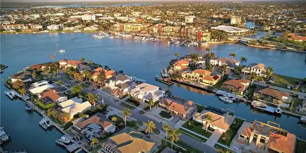 Image 2: Aerial view of property and surrounding area featuring a nearby body of water and nearby suburban area