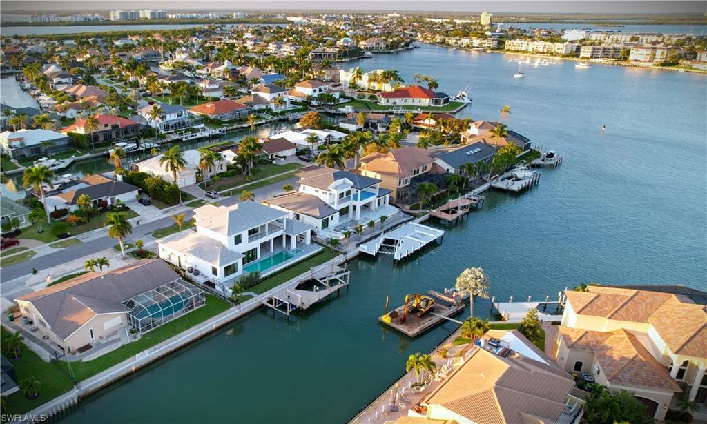 Image 3: Aerial view of residential area featuring a nearby body of water