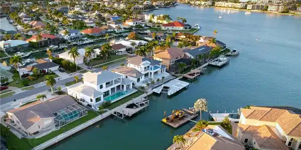 Image 3: Aerial view of residential area featuring a nearby body of water