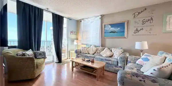 Image 3: Living area with a wall of windows, a textured ceiling, and wood finished floors