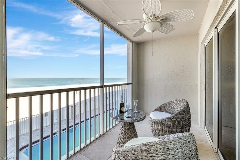 Image 3: Balcony with a ceiling fan, view of water and beach, and view of pool