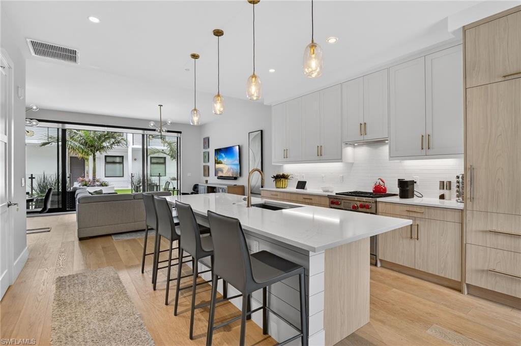 Image 2: Kitchen with light brown cabinets, white cabinetry, and recessed lighting