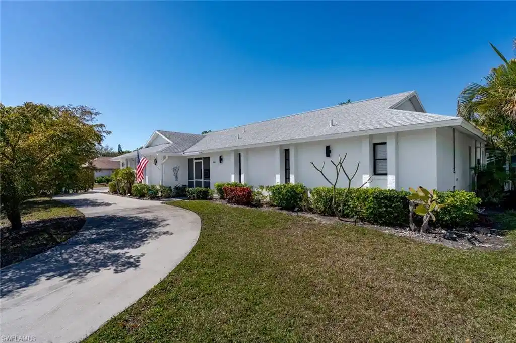 Image 1: View of front of home featuring stucco siding, a front yard, and a shingled roof