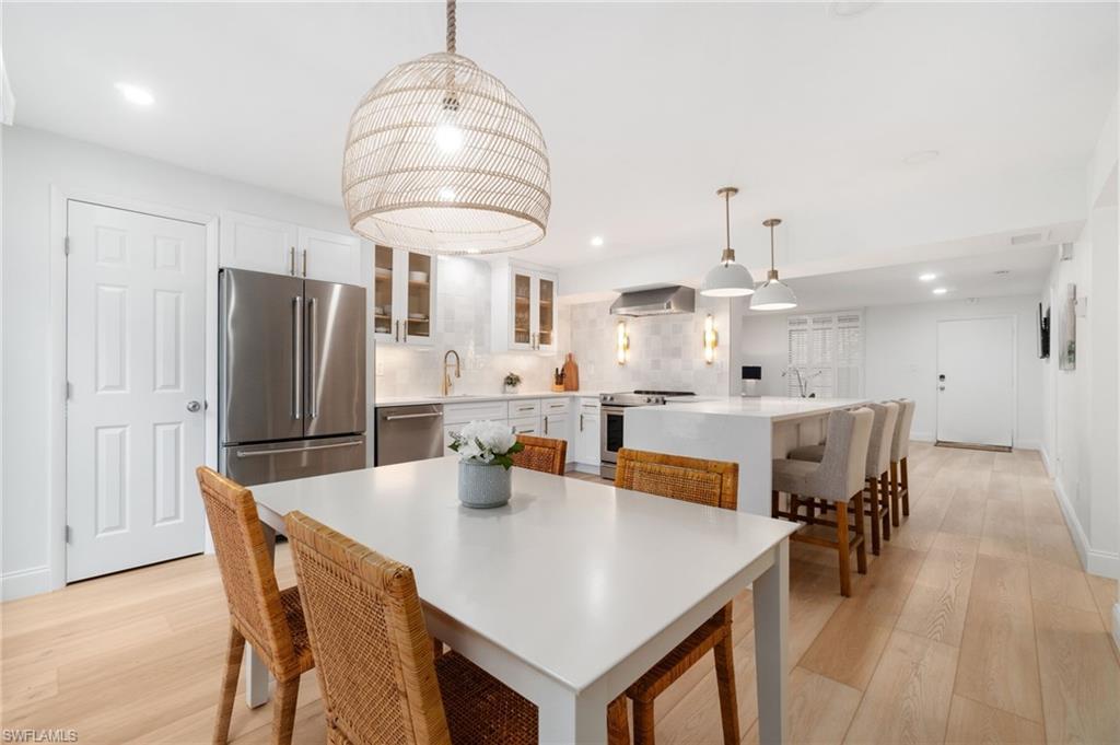 Image 2: Dining room with light wood-style floors and recessed lighting