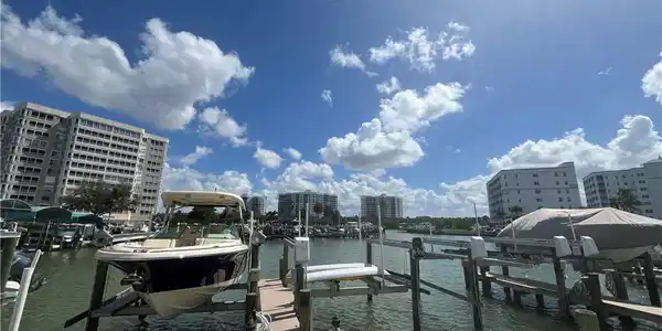 Image 2: Dock area featuring boat lift, a water view, and a view of city