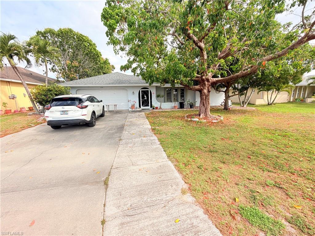 Image 2: Ranch-style house with concrete driveway, an attached garage, and a front yard