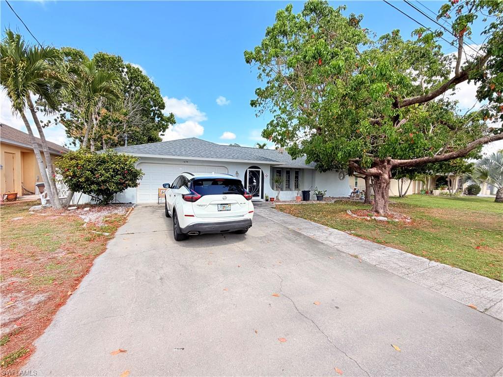 Image 3: Ranch-style house with an attached garage, a front lawn, and concrete driveway