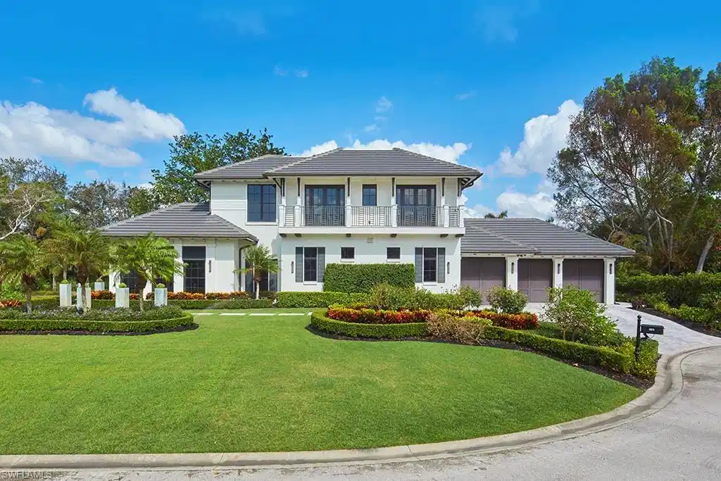 Image 1: Elegant two-story Colonial residence featuring a crisp white exterior with dark shutters and a covered front portico
