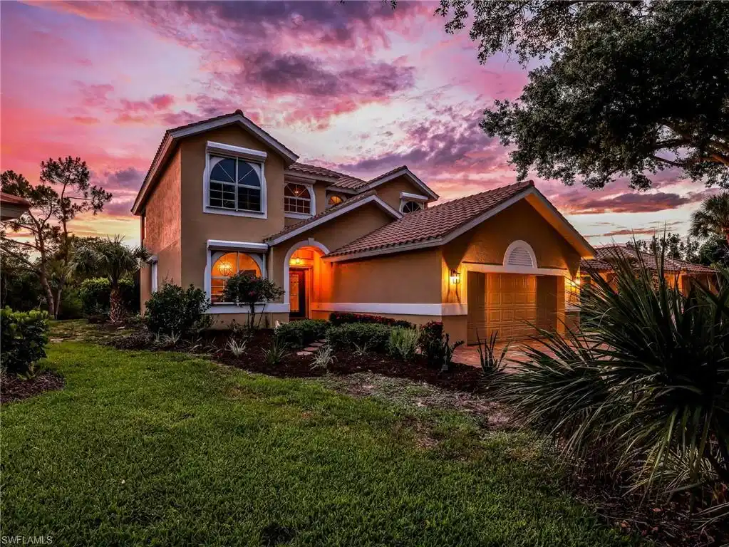 Image 1: Two-story residence featuring a terracotta tile roof, stucco exterior, arched windows, and a two-car garage