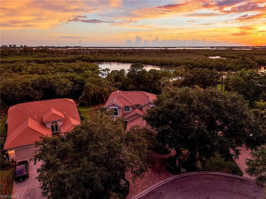 Image 2: Aerial perspective showcasing the property's red tile roof and surrounding lush foliage