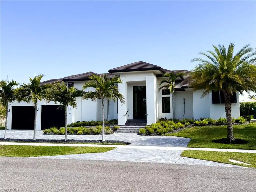 Image 1: Contemporary stucco exterior with a dark tile roof