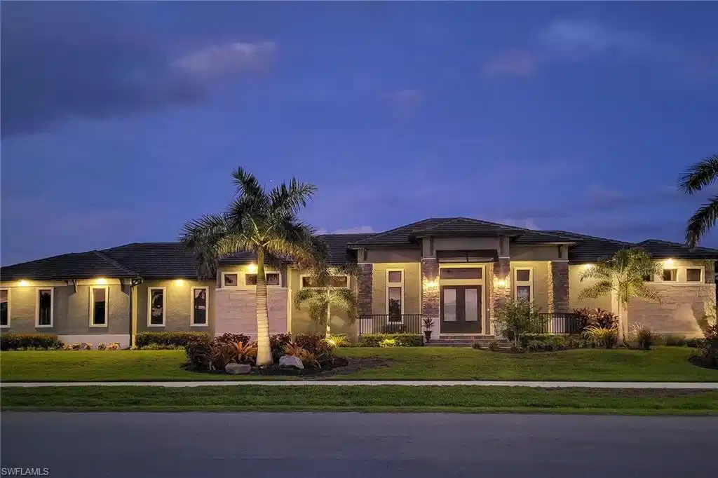 Image 1: Modern single-story residence with a dark roof and light-colored exterior