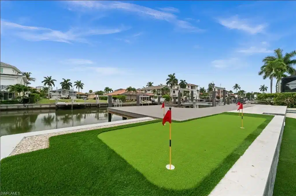 Image 1: putting green overlooking the gulf access canal and boat dock