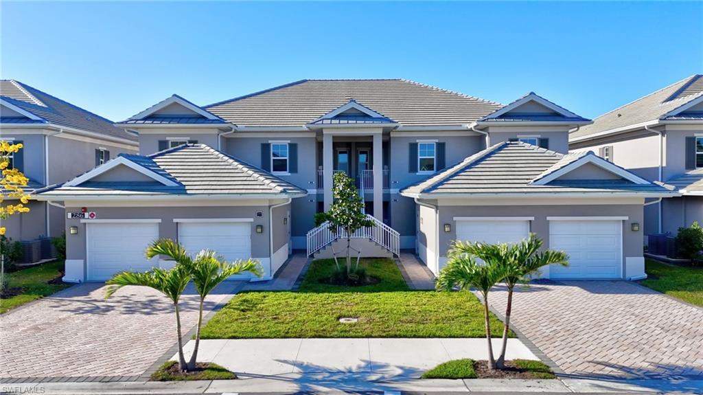 Image 1: Contemporary multi-level residence featuring a tile roof, stucco exterior, two-car garage, paver driveway, and a manicured lawn with tropical landscaping