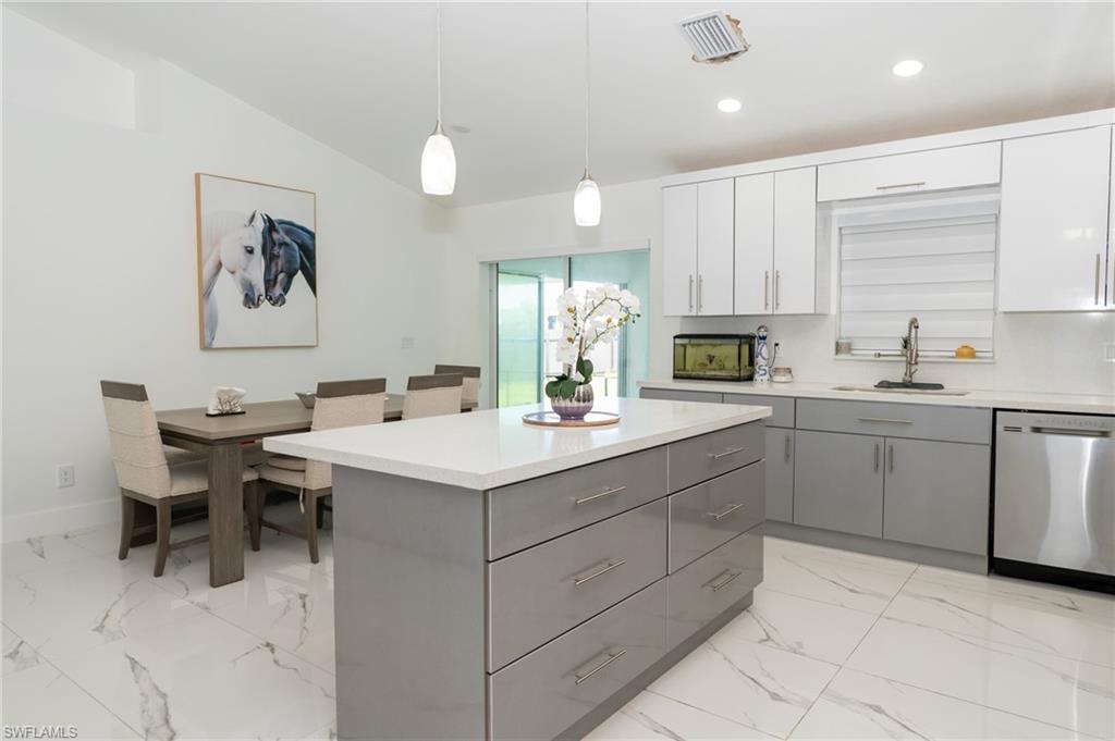 Image 1: Kitchen with gray cabinetry, dishwasher, a center island, pendant lighting, and light marble finish flooring
