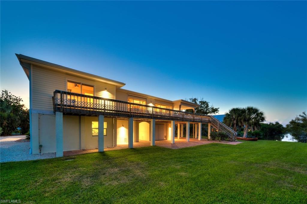 Image 3: Back of property featuring a patio area, a lawn, and stairway