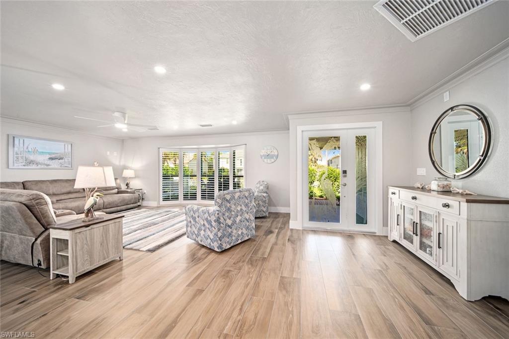 Image 4: Living room with light wood-style floors, recessed lighting, ceiling fan, a textured ceiling, and ornamental molding