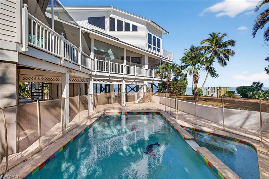 Image 3: View of swimming pool featuring a pool with connected hot tub, a balcony, stairway, and a patio area