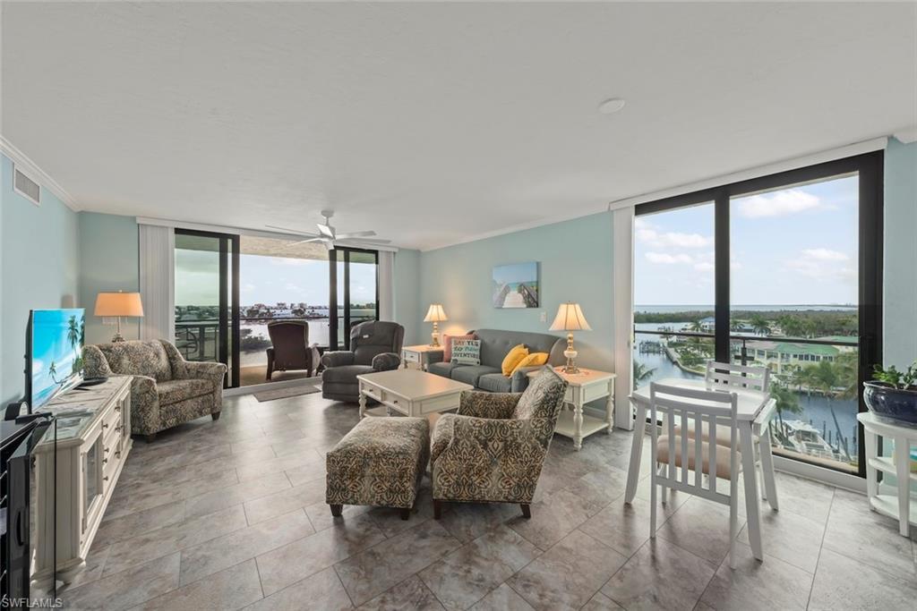 Image 3: Bright open living room with 2 sets of sliding glass doors and views all around