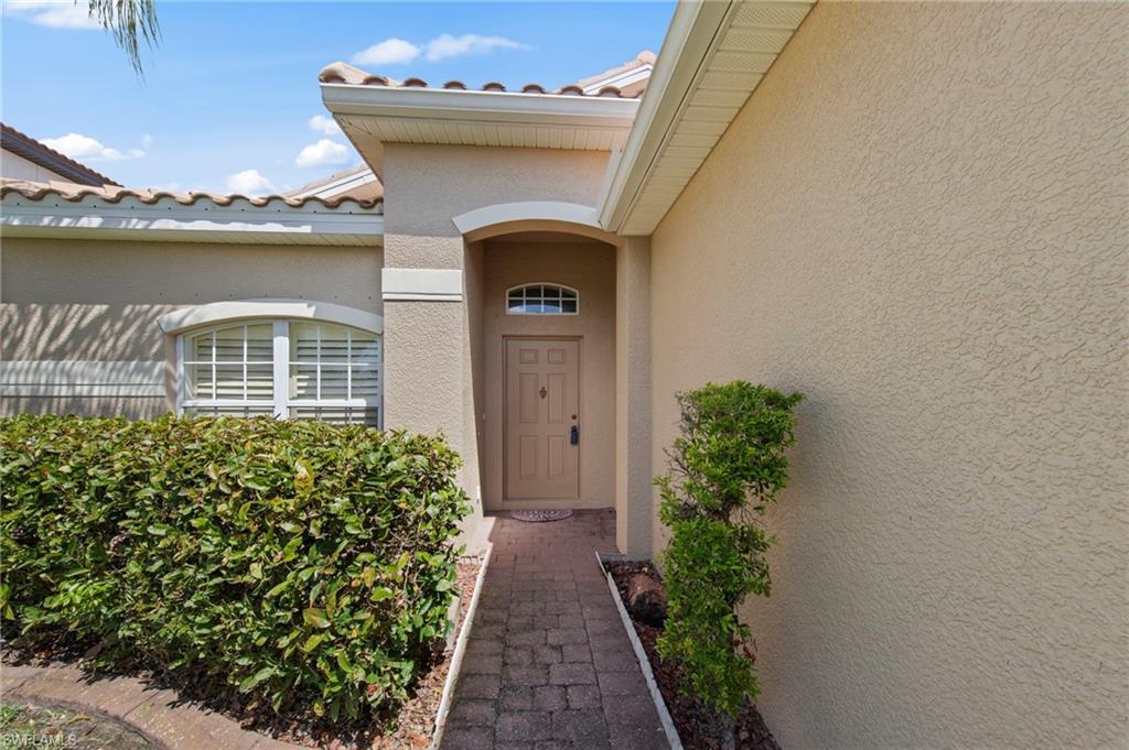 Image 3: Property entrance featuring stucco siding and a tiled roof