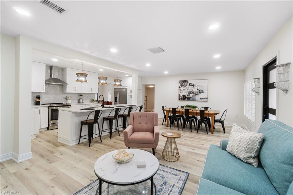 Image 3: First living area featuring light wood-type flooring and recessed lighting, open floor plan