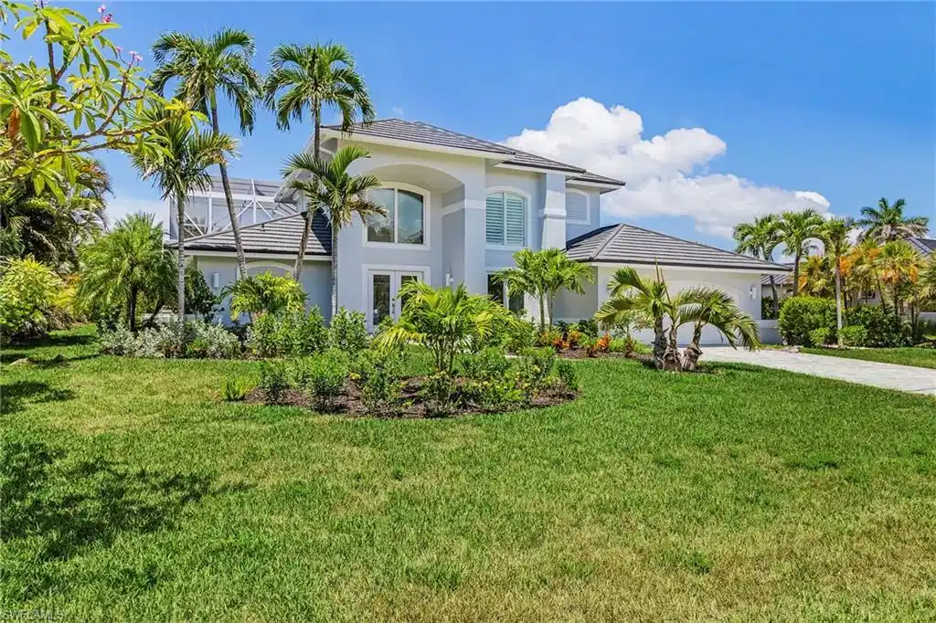 Image 1: View of front of property featuring a front yard, stucco siding, driveway, and an attached garage