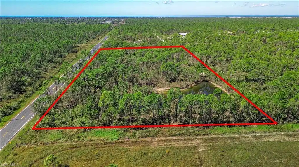Image 1: Aerial view of property's location with property boundaries highlighted and a heavily wooded area
