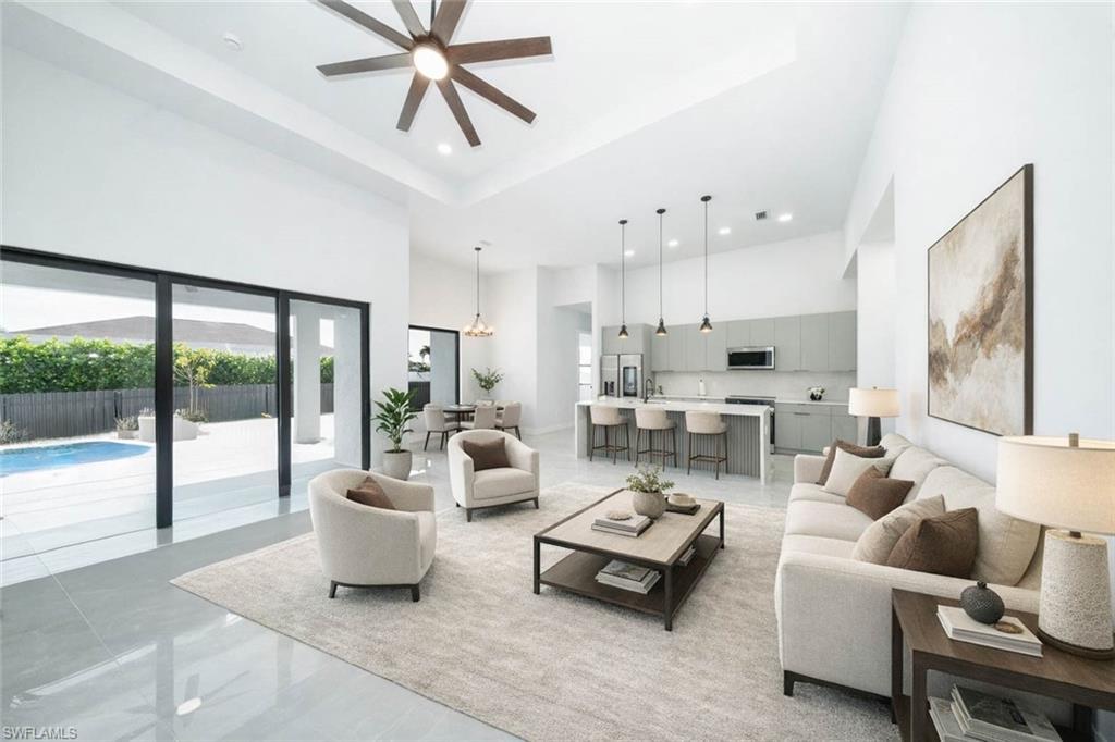 Image 2: Kitchen with stainless steel appliances, modern cabinets, gray cabinets, an island with sink, and pendant lighting