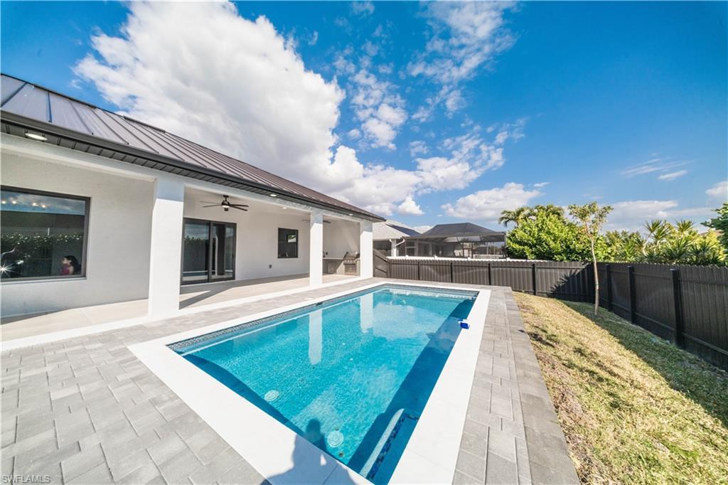 Image 4: View of swimming pool with patio surround and a fenced backyard