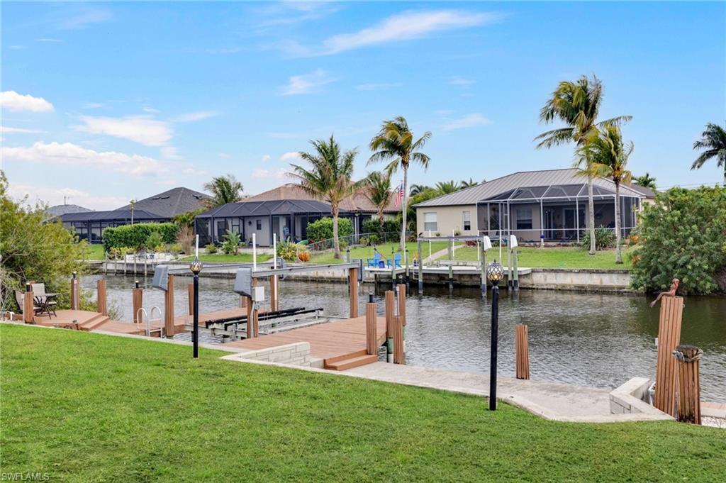 Image 4: Dock featuring a yard, a water view, a residential view, and boat lift
