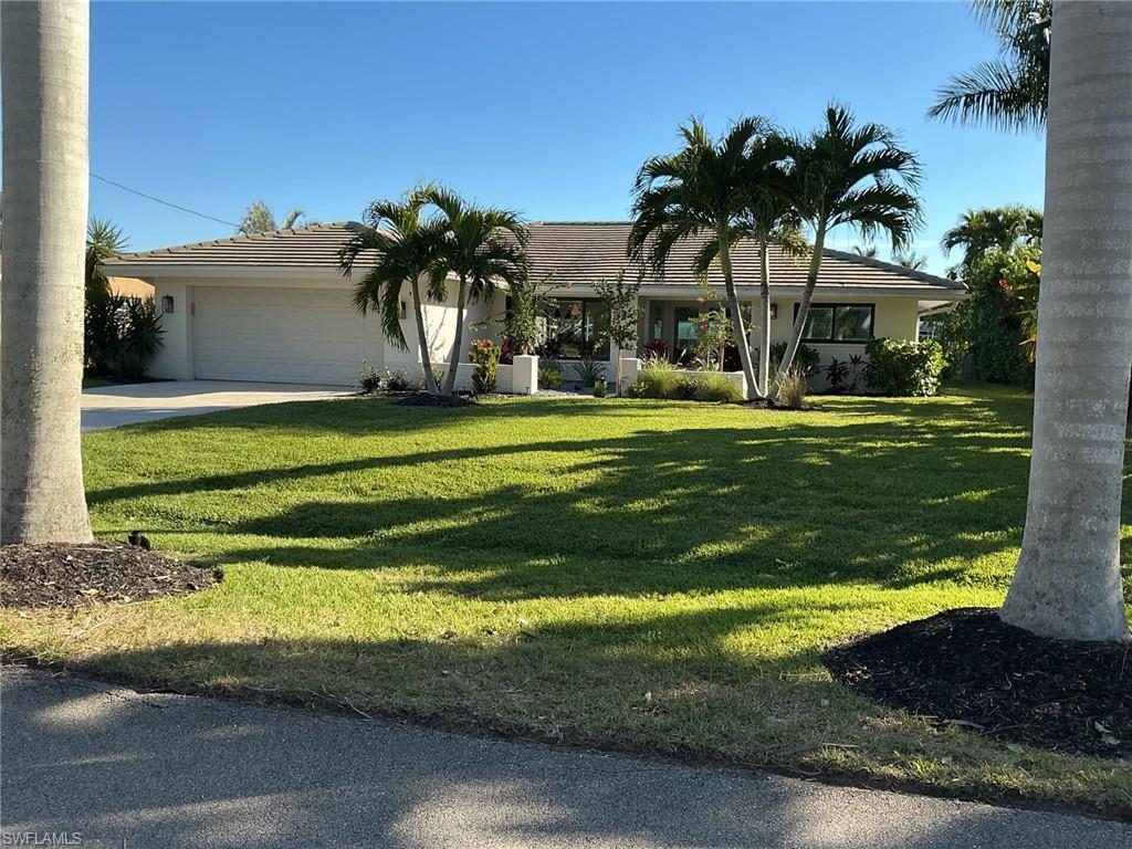 Image 2: Ranch-style home with a garage, a front lawn, driveway, a tile roof, and stucco siding
