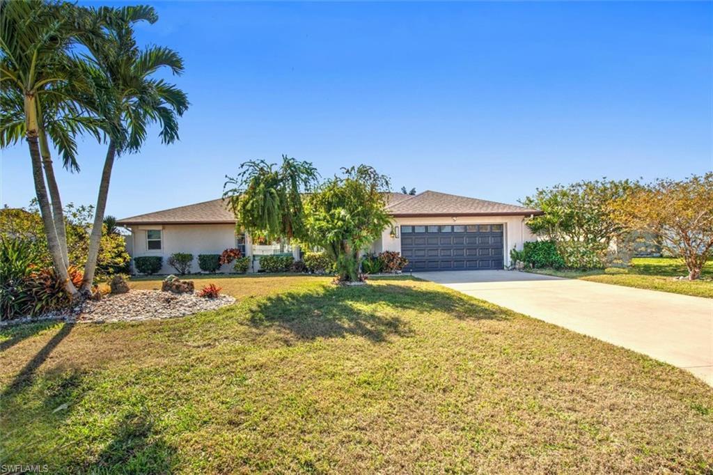 Image 3: View of front of home with a front lawn, concrete driveway, a garage, and stucco siding