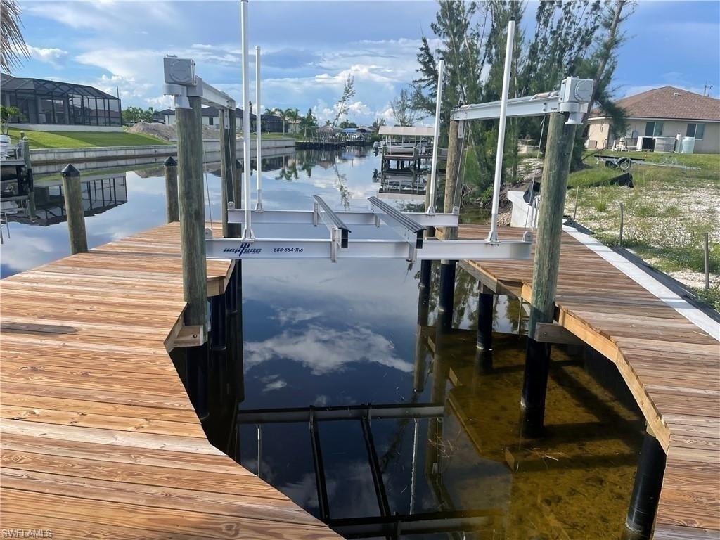 Image 2: Dock featuring a water view and boat lift