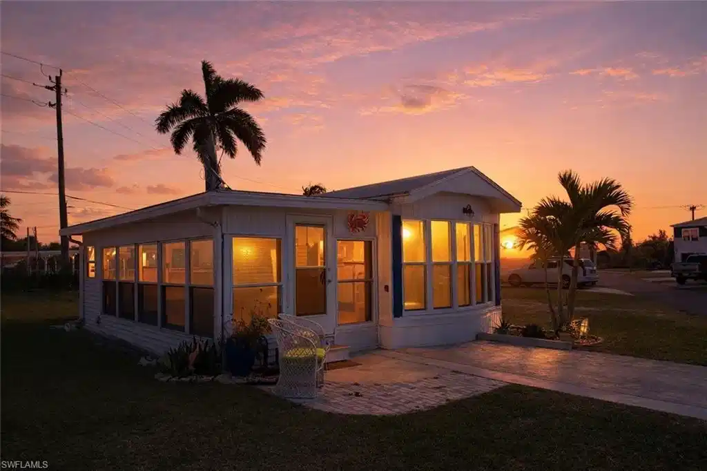 Image 1: View of front of property with a front yard, a patio area, and a sunroom