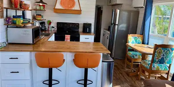 Image 3: Kitchen featuring wood counters, black electric range, range hood, freestanding refrigerator, and dark wood finished floors