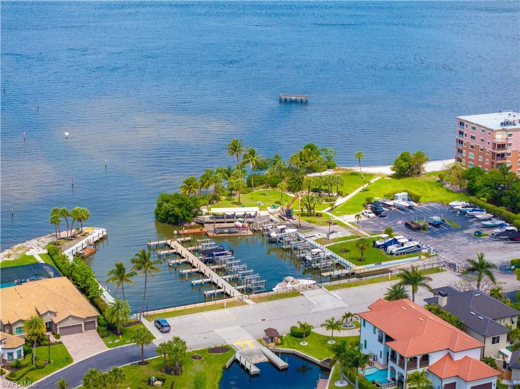 Image 3: This aerial view highlights the property's proximity to a body of water with docks, a sandy beach, and lush green spaces
