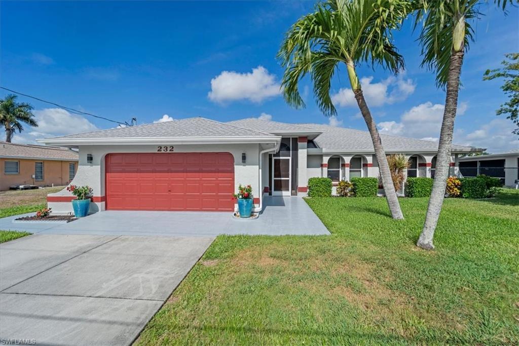 Image 1: Single-story residence featuring a red garage door, an asphalt driveway, and a concrete walkway