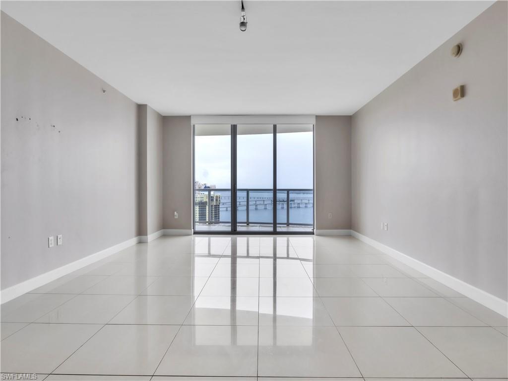 Image 1: Spare room with a wall of windows and light tile patterned floors