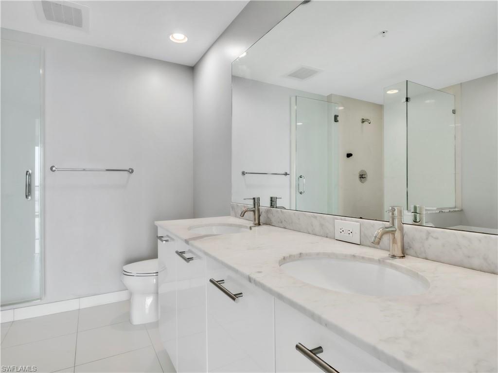 Image 4: Full bathroom featuring a shower stall, light tile patterned flooring, double vanity, and recessed lighting