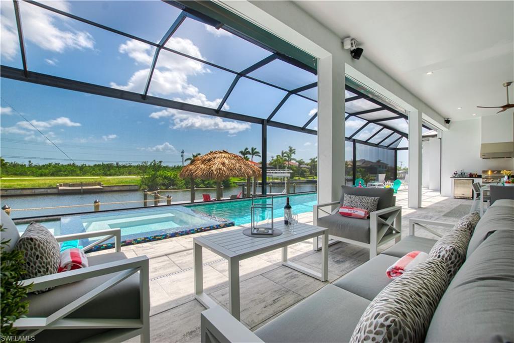Image 2: Expansive screened lanai featuring an outdoor kitchen, inground pool and spa, and canal frontage