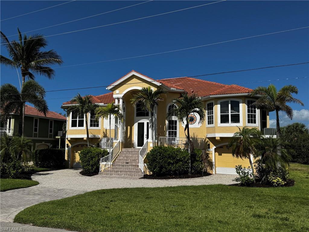 Image 2: Mediterranean-style residence featuring a terracotta tile roof and light yellow stucco exterior