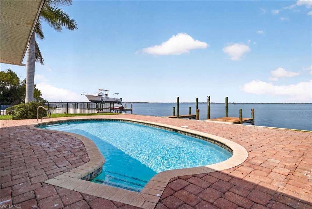 Image 2: Freeform swimming pool with integrated steps, surrounded by brick paver decking