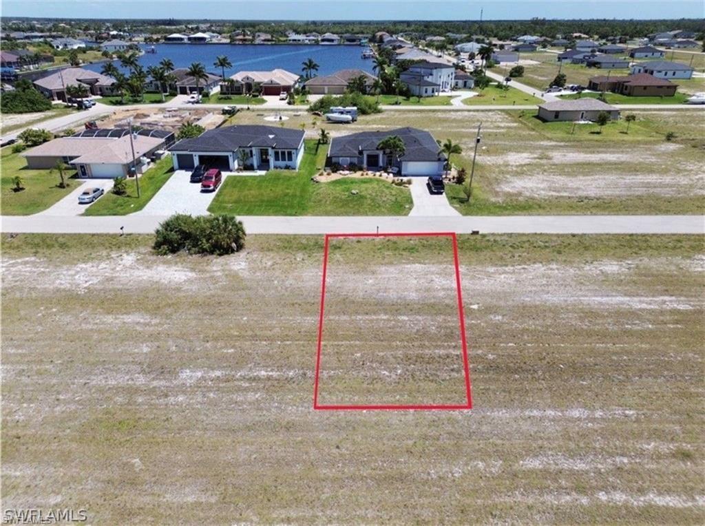 Image 1: Vacant residential lot outlined in red, featuring a flat, cleared terrain