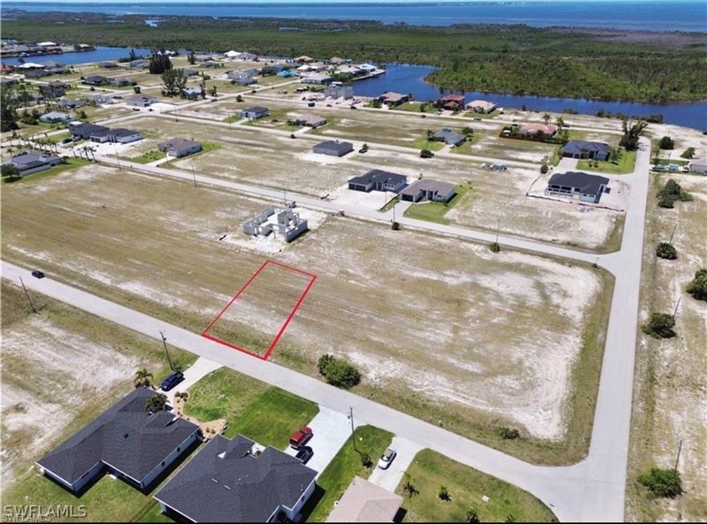Image 3: Cleared building lot with canal access featuring a nearby waterfront and established neighborhood infrastructure